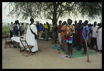 Sudan, Kongor, Church service in war famine zone, the church is the shade under the tree.