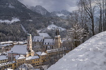 Germany, Bavaria, Berchtesgaden, Stiftskirche and Pfarrkirche St Andreas from the snow covered Brine Line Cliff Walk above the town.