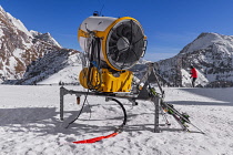 Germany, Bavaria, Berchtesgaden, Berchtesgadener Alps, snow machine on  the summit of the Jenner Mountain with skiers in the background.