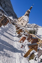 Germany, Bavaria, Ramsau village,  Angular view of the Church of  St Sebastian with its graveyard in a snow covered landscape.