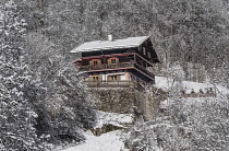 Germany, Bavaria, Ramsau village, Typical Alpine house in a snow covered landscape above the village.