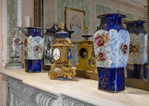 Ireland, County Galway, Connemara, Kylemore Abbey, The Gallery Saloon Room, Ornate clock and vases on marble fireplace.