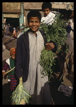 Egypt, Sakkara, Boy in the market holding goods Saqqara .