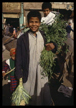 Egypt, Sakkara, Boy in the market holding goods Saqqara .