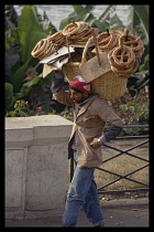 Egypt, Cairo, Bread seller with large basket of assorted breads on his shoulder.