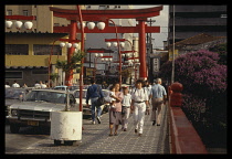 Brazil, Sao Paulo, Busy street scene in the Japanese quater with large red gate and hanging lanterns over the road.