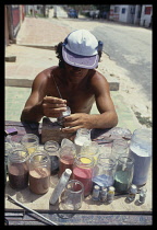 Brazil, Crafts, Man making sand pictures in glass bottles with different coloured sand.