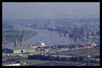 France, Normandy, Seine-Maritime, Rouen, View over docks with cranes and container vessels on the River Seine to the west of Rouen with capacity for ocean-going ships.