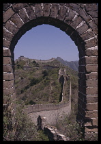 China, Near Beijing, Great Wall, View through brick archway and along the wall disappearing over hills.