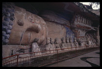 China, Sichuan , Dazu, Large reclining Buddha with line of smaller figures along its side. .