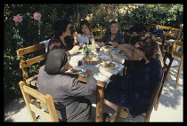 Greece, Pilion, Family having outdoor lunch around table.