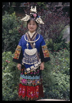 China, Guizhou , Kaili, Miao woman in traditional dress  portrait standing  full length.