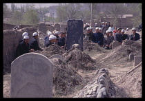 China, Gansu Province, Lanzhou, Praying in Muslim graveyard at end of Ramadan.