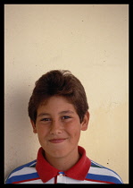 Greece, Ionian Islands, Corfu, Young teenage boy wearing red white and blue shirt.