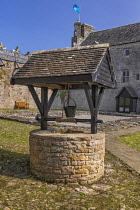 Ireland, County Leitrim, Dromahair, Parkes Castle, Wishing well in the courtyard with the castle itself in the background.