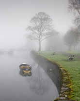 Ireland, County Sligo, Sligo town, Doorly Park, Boat on the River Garavogue on a foggy winter's morning.