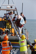 England, Kent, Dungeness, RNLI, helping migrants who have crossed the channel onto the beach.