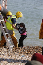 England, Kent, Dungeness, RNLI, helping migrants who have crossed the channel onto the beach, Susina 5yrs old and traveled with her mum from Eritrea.