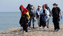 England, Kent, Dungeness, Immigration officers escorting recently landed migrants to be processed, Susina 5yrs old and traveled with her mum from Eritrea.