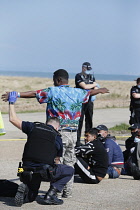 England, Kent, Dungeness, Migrants being searched by immiragtion officers on the beach.