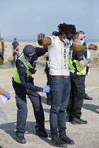 England, Kent, Dungeness, Migrants being searched by immiragtion officers on the beach.