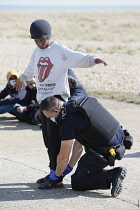 England, Kent, Dungeness, Migrants being searched by immiragtion officers on the beach.