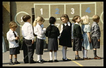 Education, Primary School, Line of primary school children in uniform standing in playground..