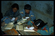 China, Tibet, Shigatse, Primary school children sitting at desks writing for PRA.