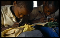 Tanzania, Near Shinyanga, Bugwandege Primary School children working at desks.This school was built by the villagers the teachers are paid by Govt but parents pay for everything else.