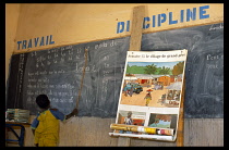 Mali, Pays Dogon, Tirelli, A boy at the chalkboard in classroom chanting French vowel sounds at school.