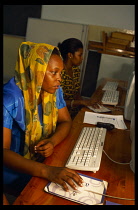 Tanzania, Education, Two women sitting at computers during training class for Health workers.