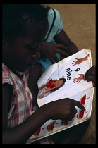 Ghana, General, Child learning numbers from book.