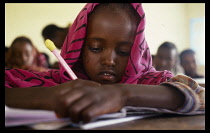 Somalia, Baidoa, Schoolgirl writing at desk.