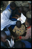 Somalia, Habare Village, Unicef worker showing group of children how to use new textbooks.