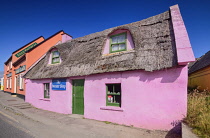 Ireland, County Clare, Doolin, Colourful craft shop known as The Sweater Shop with bright pink wall in the village.
