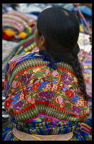 Guatemala, Antigua Guatemala, Woman from the village of San Antonio Aguas Calientes wearing huipil  traditional back strap woven blouse  seen from back.