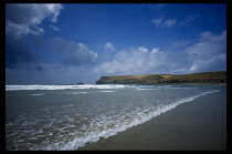 England, Cornwall, Pentire Point, View over empty beach towards headland.