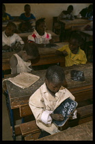 Mali, Pays Dogon, Tirelli, Children sitting at desks chalking on their slates in classroom at the school during french lessons.