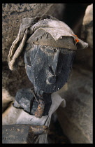 Mali, Pays Dogon, Yaye, Old carved wood Dogon head with cloth hat and iron bell.