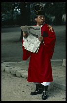 South Korea, Seoul, Confucian devotee reading newspaper during break from Rites.