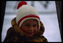 Russia, Moscow, Head and shoulders portrait of child wrapped up against the cold outside in snow.