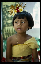 Indonesia, Bali, Children, Portrait of young girl in traditional dress attending cremation ceremony.