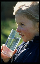 England, Children, Young girl drinking from glass of water.