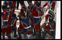 Mongolia, Ulaanbaatar, National Day band taking a break from playing  some resting on their instruments.  Wearing red  blue and gold uniform.