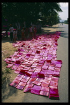 Vietnam, Central, Near Danang.  Books  dyed pink and laid out to dry on roadside before being made into firecrackers.