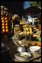 Indonesia, Bali, Gianyar Regency, Rice cakes and other temple offerings of fruit and flowers  some in silver bowls.