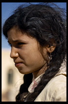 Algeria, Racial Traits, Children, Head and shoulders portrait of young girl with dark hair in plaits.  Profile to the left.