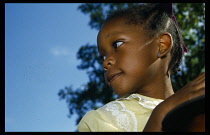 England, Children, Head and shoulders portrait of little girl watching the Notting Hill Carnival with face turned to left.