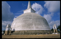 Sri Lanka, Anuradhapura, Ruvanveli Seya dagoba raised in the second century by Dutugemunu. White exterior standing in paved courtyard with visitors circling the base.