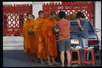 Thailand, Bangkok, Monks collecting Alms outside Marble Temple. Wat Benchamabophit.